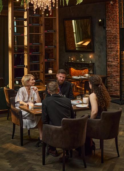 Vertical shot of business team dining and discussing strategy during restaurant meeting, representing corporate networking and partnership building. Ideal for leadership, client relations marketing
