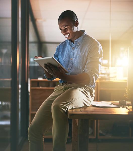 Business, smile and black man with a tablet, typing and online reading with software, modern office and happiness. Male person, employee or entrepreneur with technology, connection and communication.