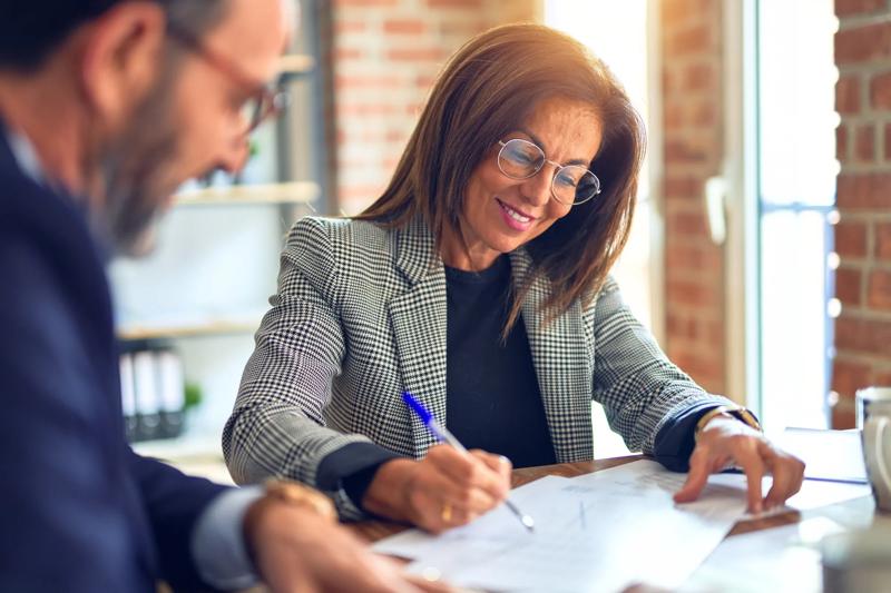 Two middle age business workers smiling happy and confident. Working together with smile on face at the office