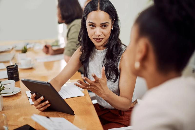 Do you get what Im saying. a young businesswoman using a digital tablet while having a discussion with a colleague in an office