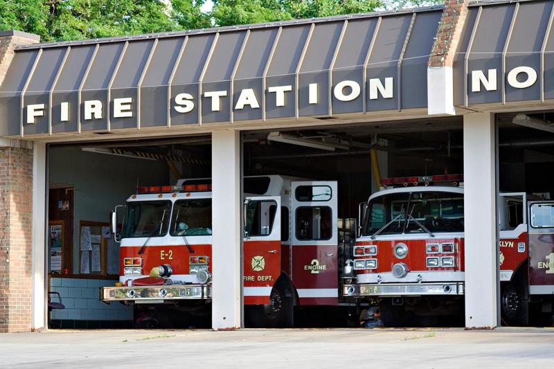 A city fire station - doors open and trucks waiting.