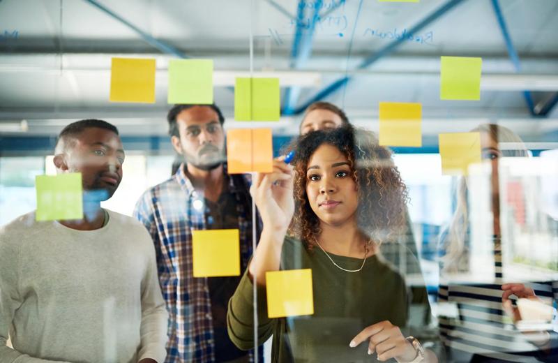 Shot of colleagues having a brainstorming session with sticky notes at work.