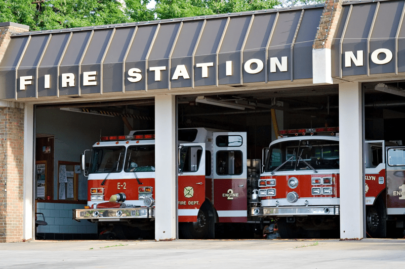 A city fire station - doors open and trucks waiting.