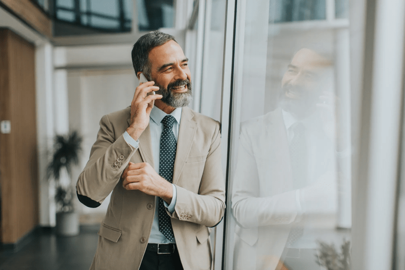 Handsome mature businessman  with mobile phone in the office