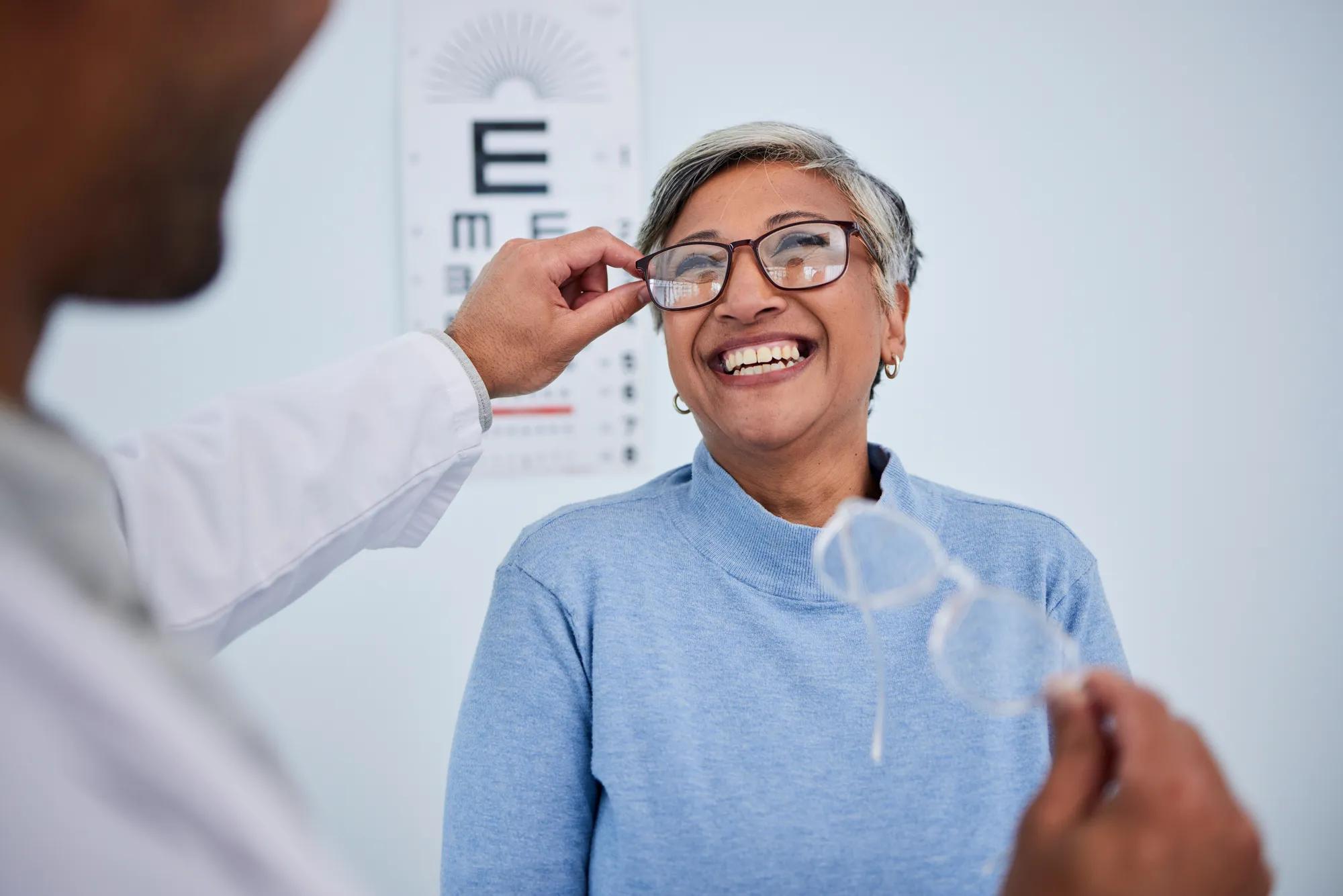 Glasses, doctor or happy old woman in eye test assessment for healthcare, wellness or vision examination. Smile, visual or mature client testing a optician or optometrist in optometry consultation.