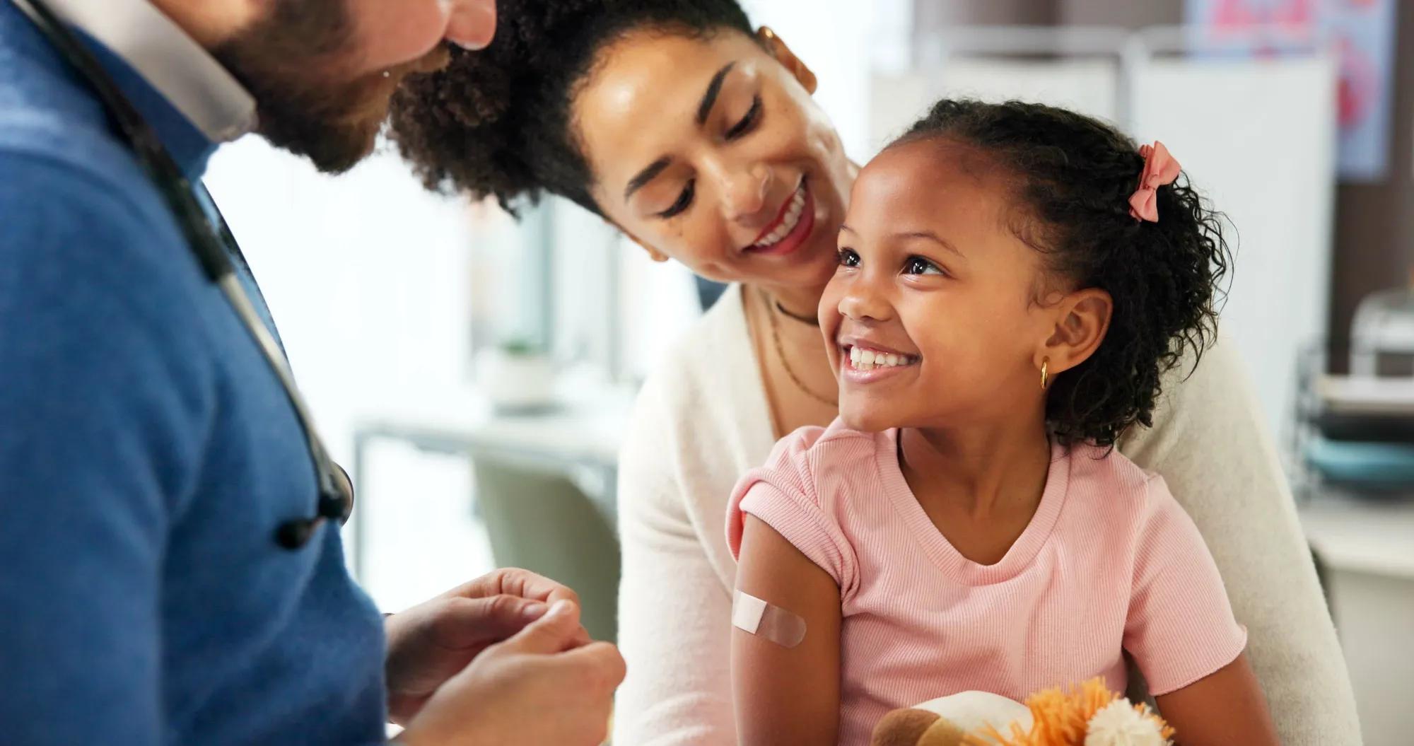 Health professional speaking with parents and smiling baby about fertility benefits, reproductive health services, and family-building support.