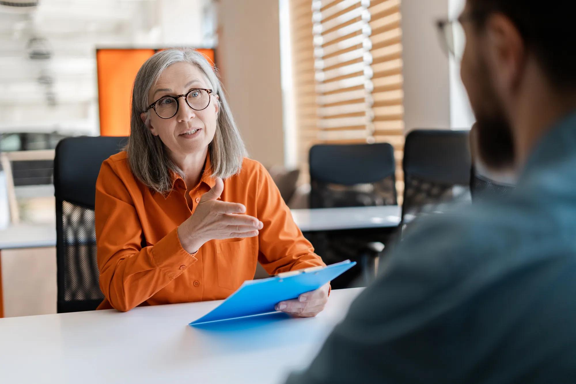 Business professionals reviewing ACA compliance documents and employee health plan information related to employer healthcare coverage, penalties, and benefits regulations.