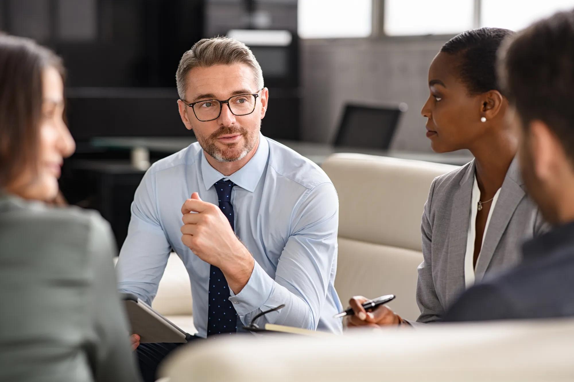 Business professionals reviewing employee benefits, financial wellness, and compliance planning documents.