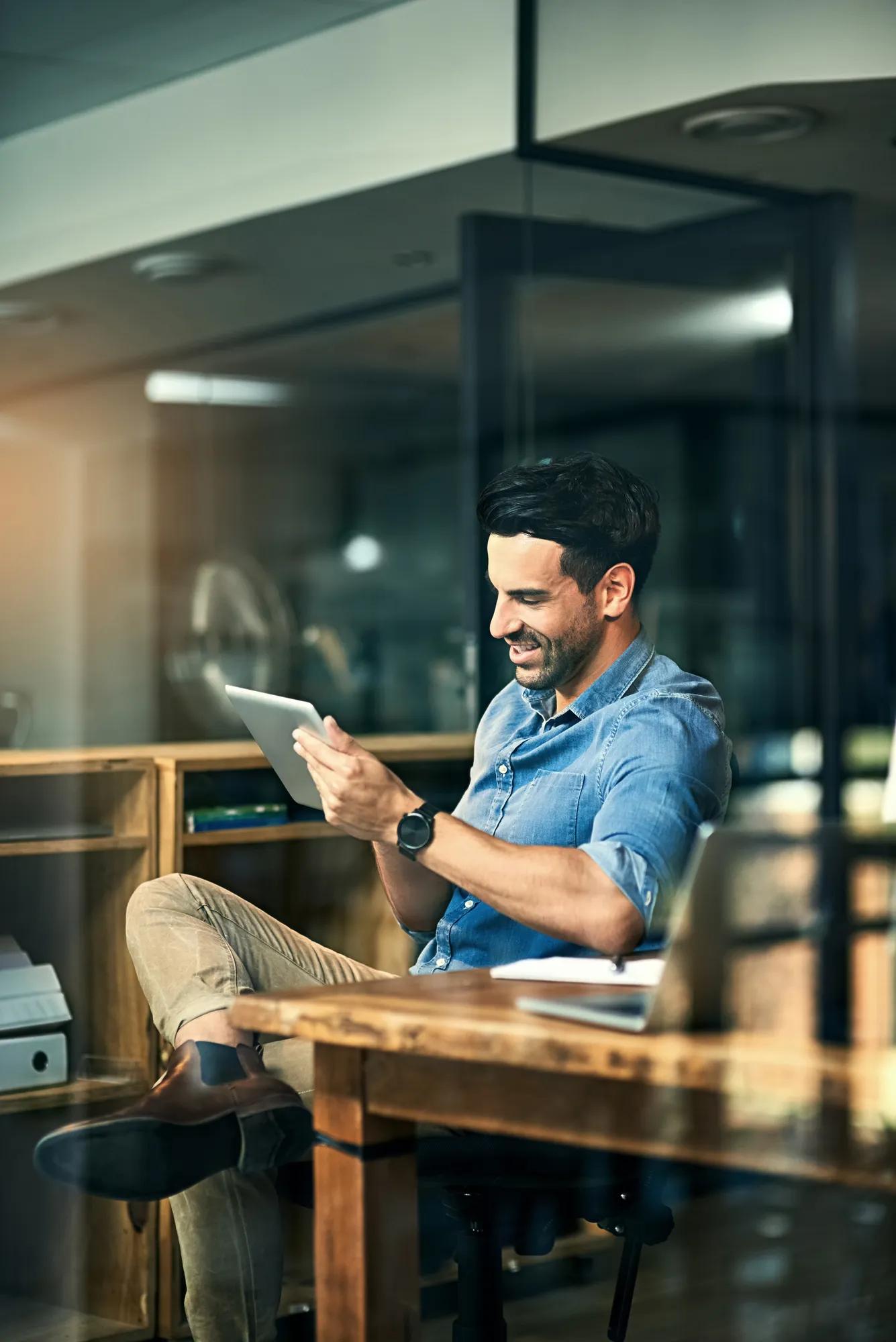Business tools just keep getting smarter and smarter. Shot of a young businessman using a digital tablet during a late night at work