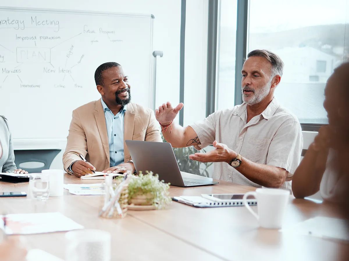 Shot of a group of staff listening to their boss during a business meeting.