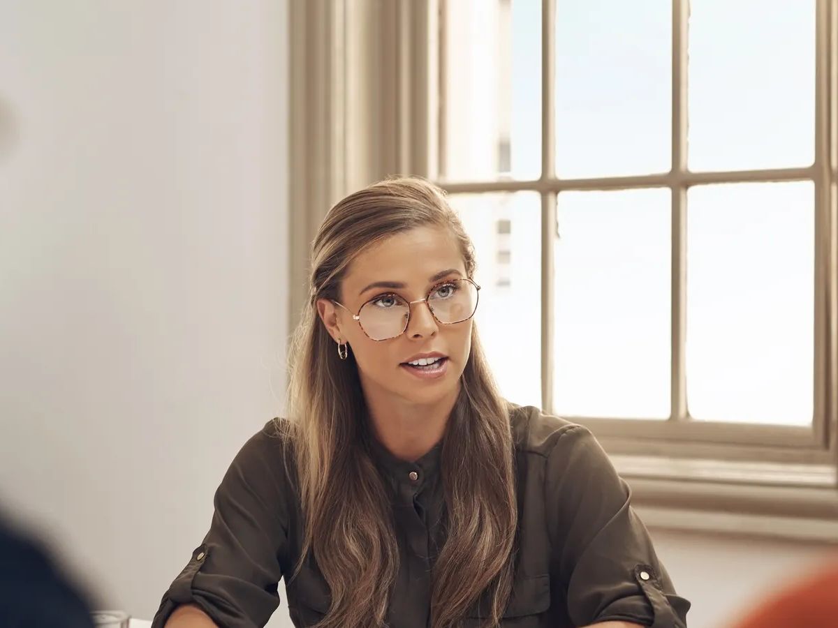 Human resources manager meeting with colleagues, settling a dispute or argument in her office. Serious female leader talking, meeting and planning with her team and staff members at work.