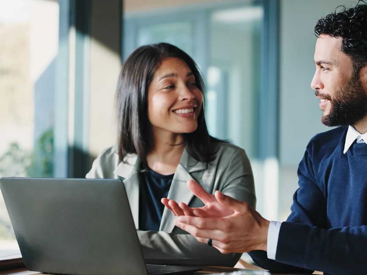 Meeting, laptop and talking with business people in office for realtor listing, discussion and research. Property developer, project manager and collaboration with employees for online review.
