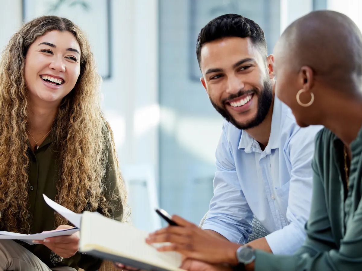 Happy business people smile during a planning meeting in a startup marketing agency office. Diversity, collaboration and teamwork in a healthy work environment in an international advertising company.