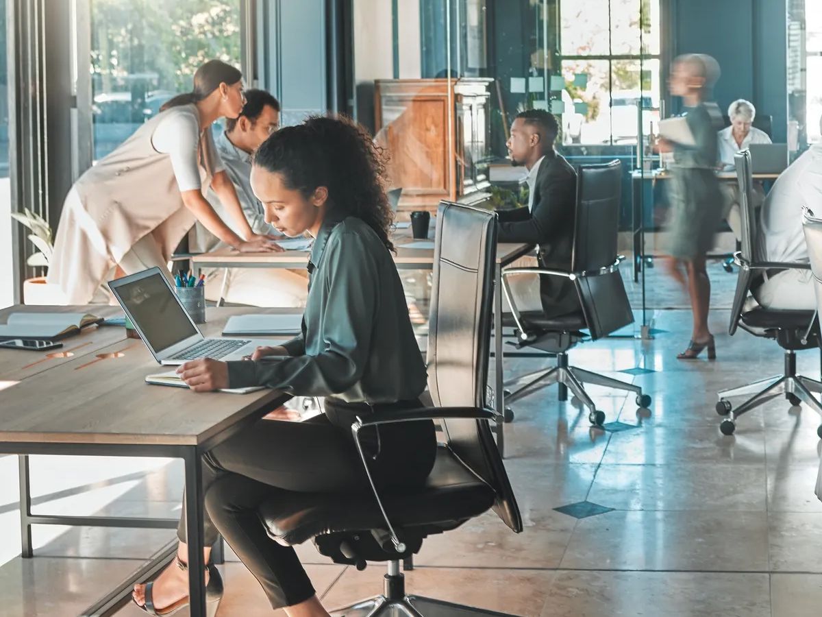 Corporate business people working in busy marketing office space, planning strategy in books and reading email on laptop at work. Businessman, businesswoman and workers at startup advertising company.