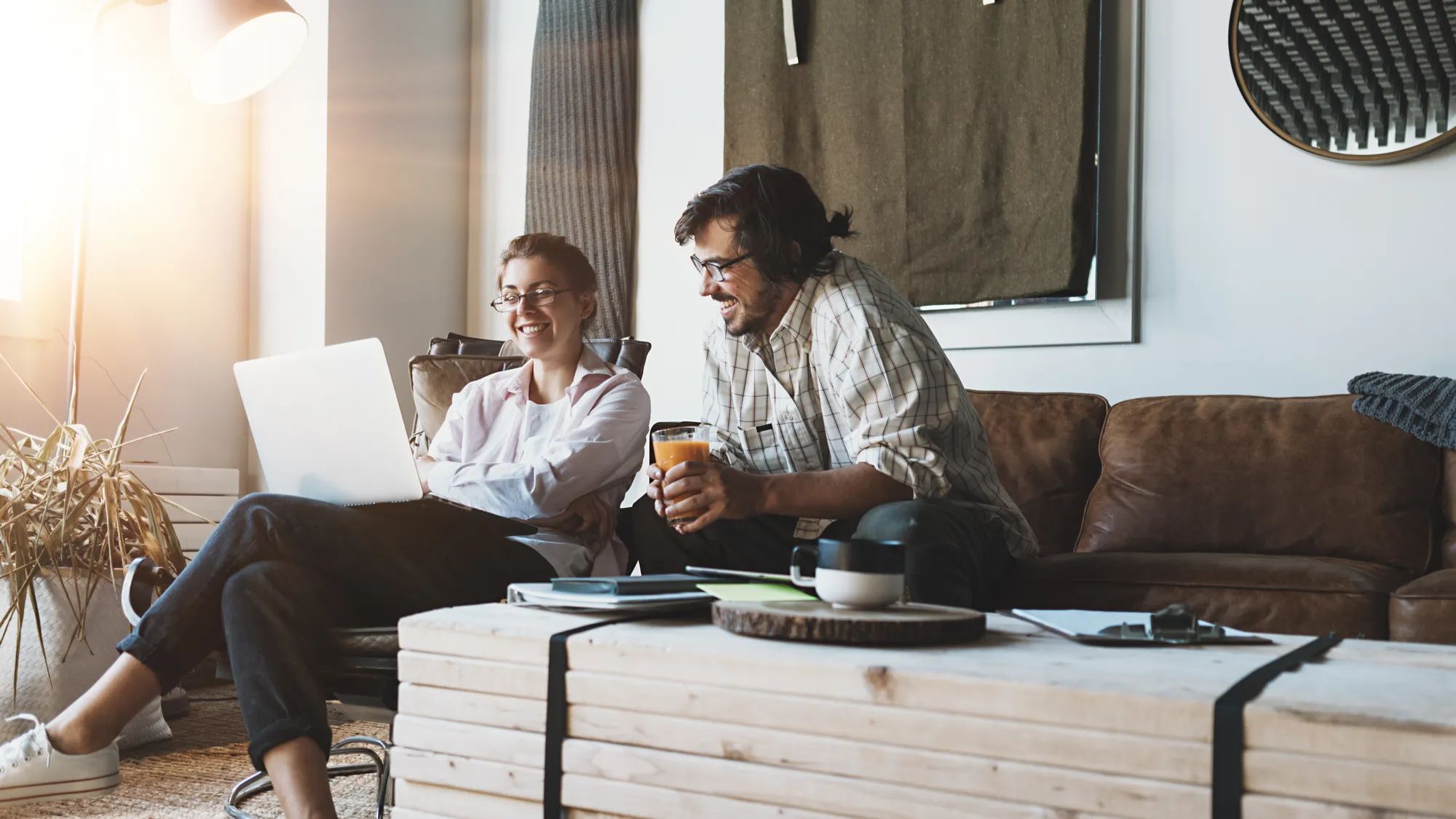 Group of two people with laptops in small loft office. Man and woman working together. Discussing positive feedback