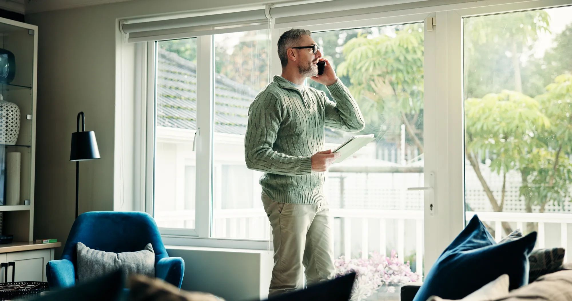 Freelancer, phone call and man with tablet in home for listening, chat or insurance policy. Remote work, mobile and mature broker talking to contact for negotiation, claims update and discussion.