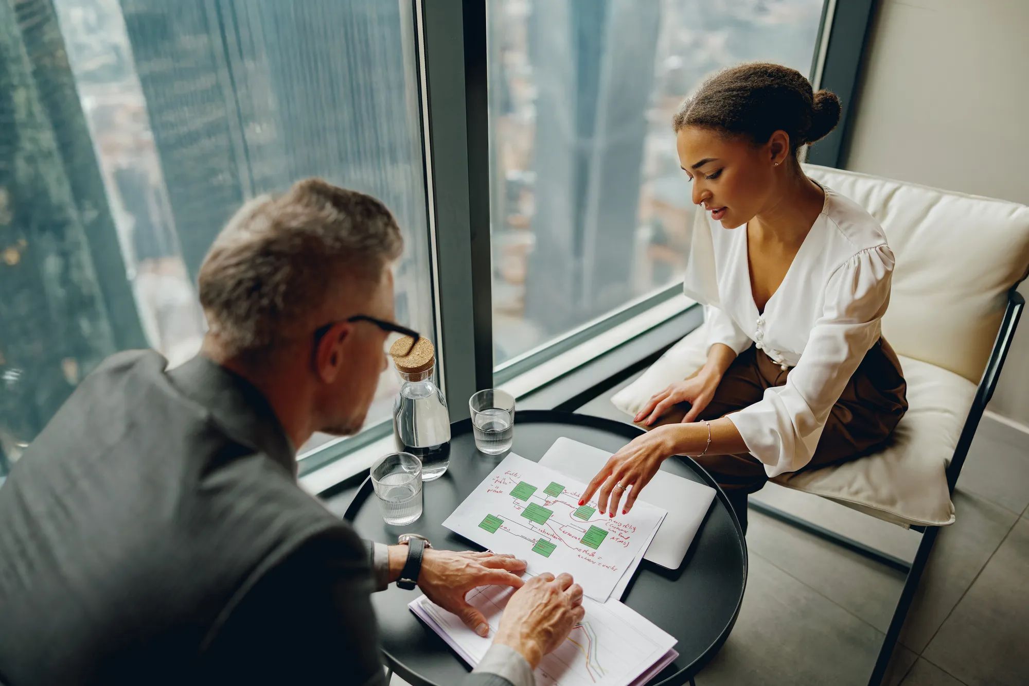 Business professionals collaborate on innovative strategies in a sleek office with stunning urban views