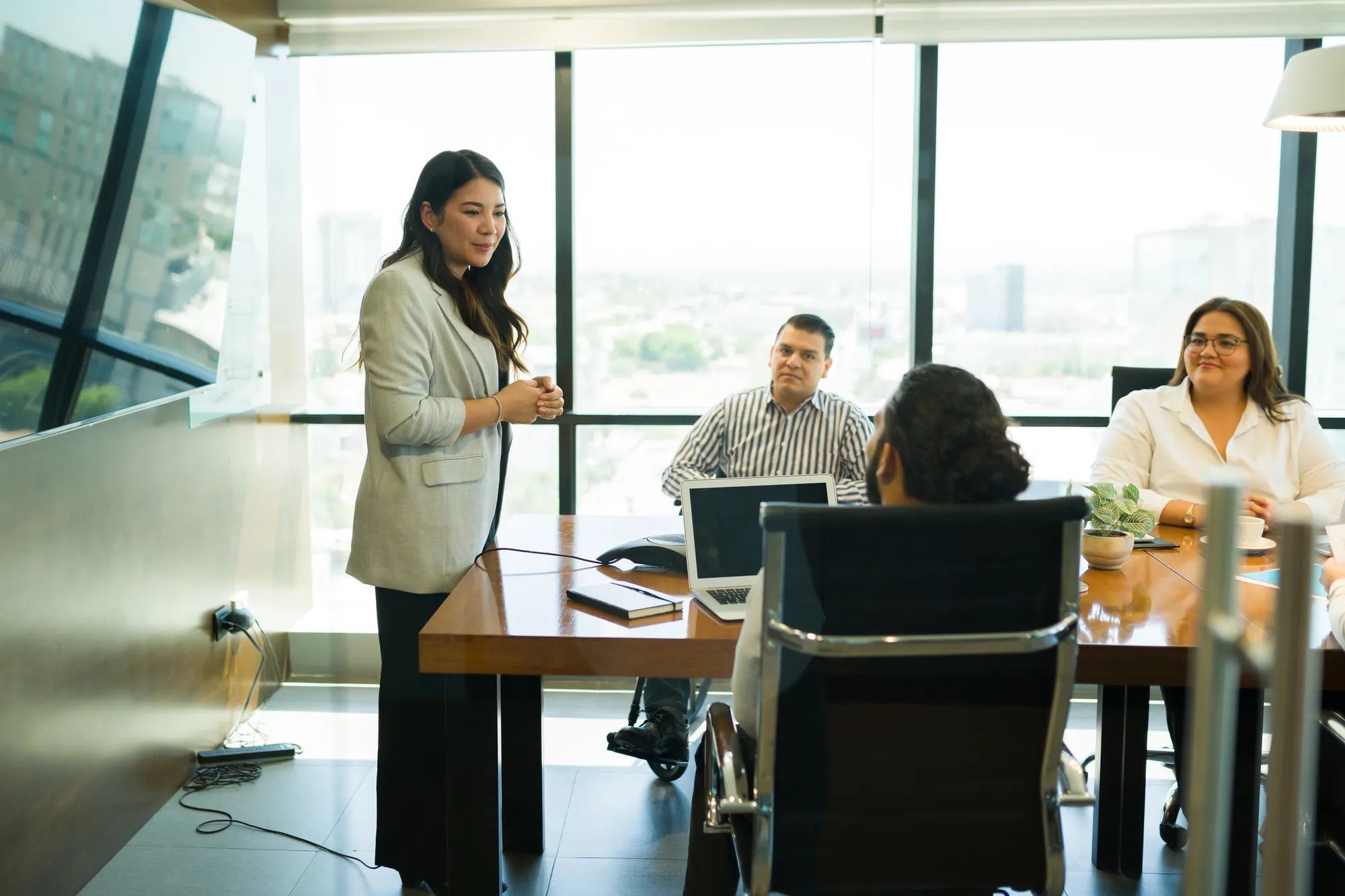 Young asian businesswoman standing at table and listening to male colleague during a presentation in office meeting room