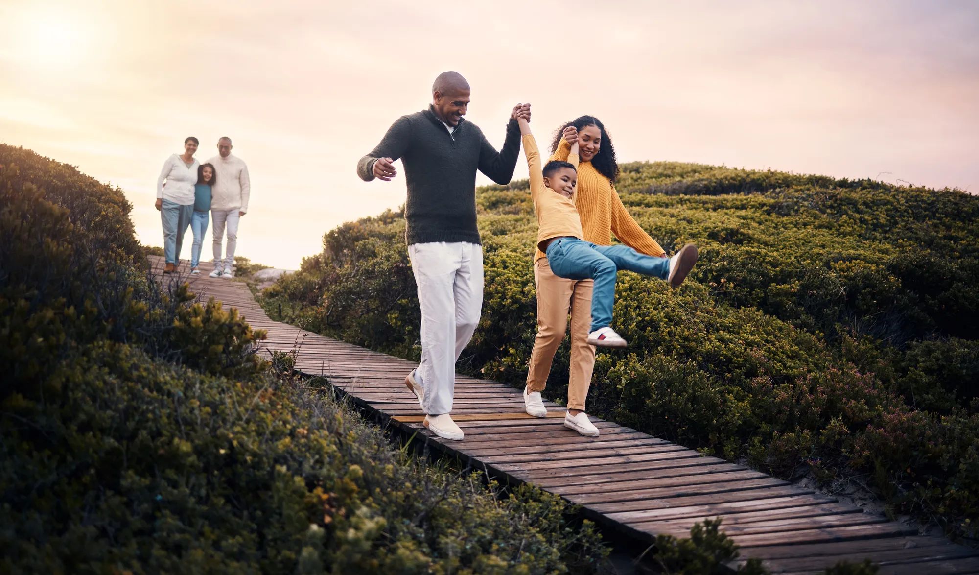 Family, walking or sunset with parents, kids and grandparents playing together outdoor in nature. Spring, love or environment with children and senior relatives taking a walk while bonding.