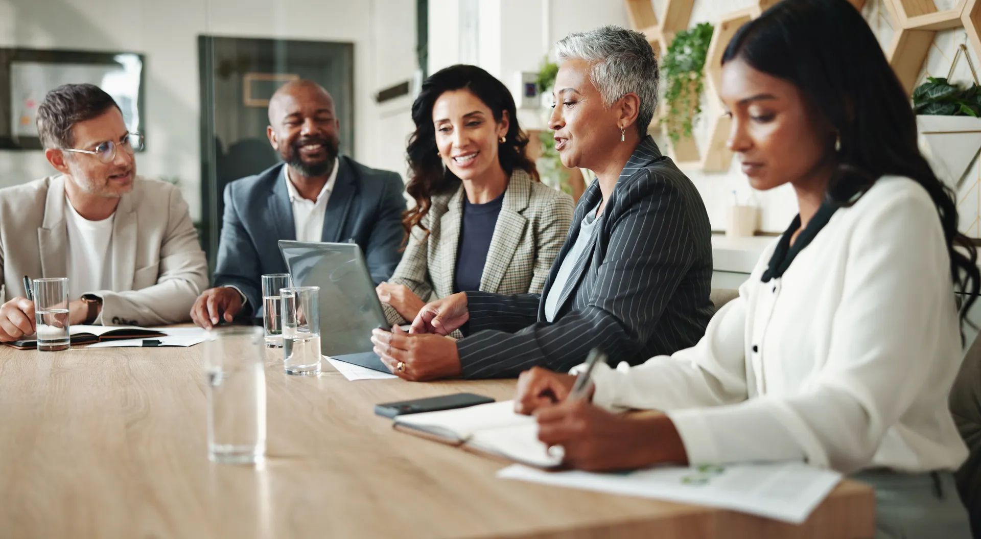 Laptop, corporate and business people in meeting with manager for feedback, website and online project. Office, teamwork and men and women with documents for collaboration, planning and proposal.