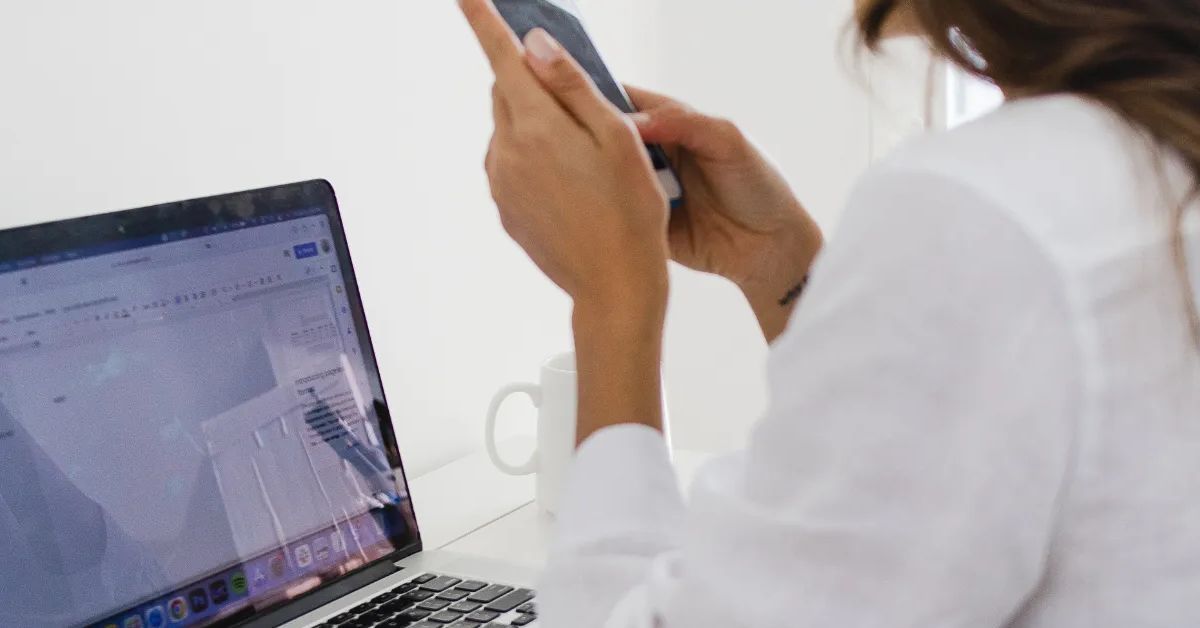 Woman distracted by phone while working