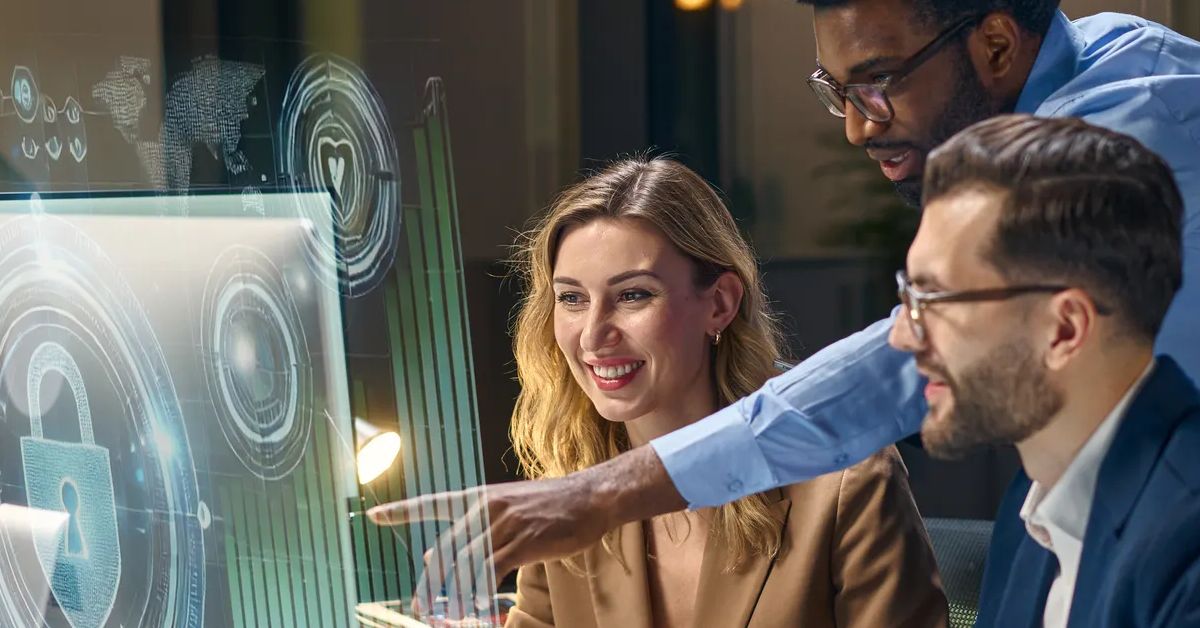 Team collaborating on cybersecurity solutions, analyzing futuristic hologram interfaces in office setting.