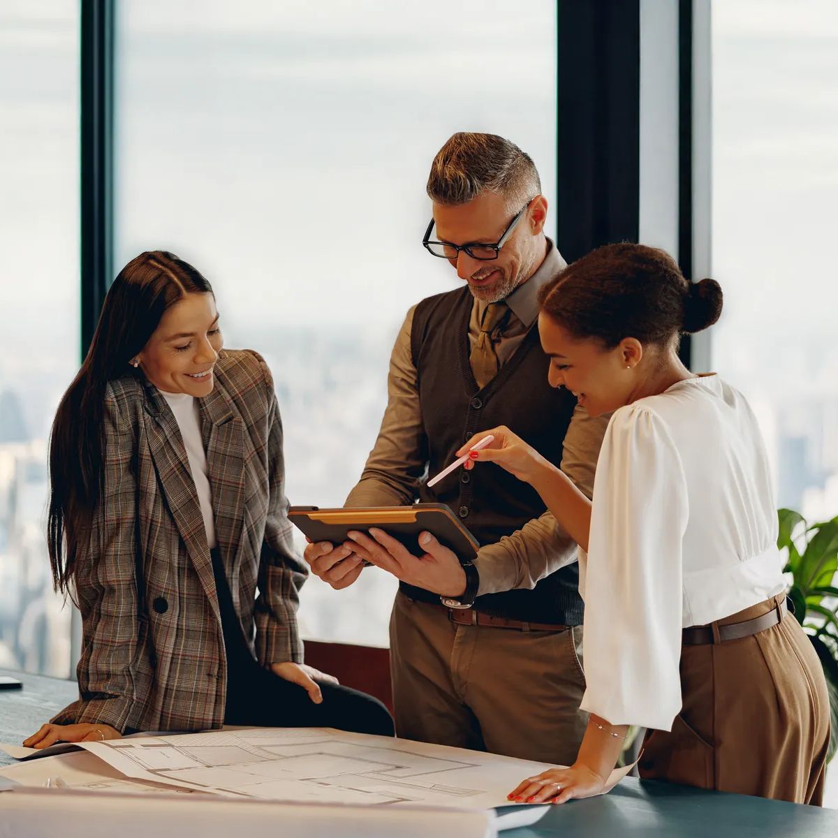 A skilled team is collaborating on a major project in a modern office with inspiring city skyline views