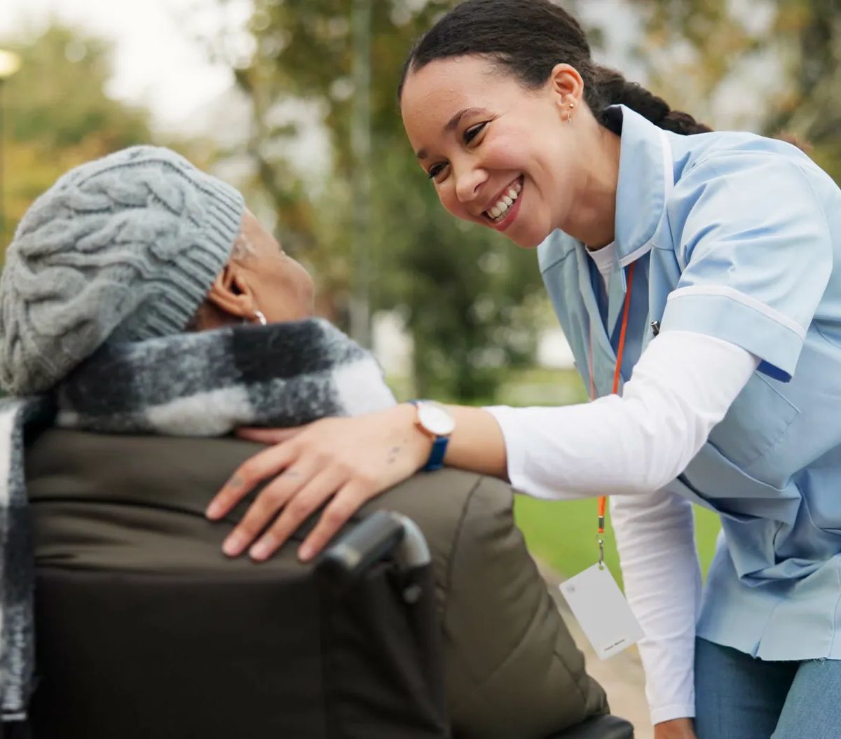 Nurse, happy and park with old woman in a wheelchair for retirement, elderly care and physical therapy. Trust, medical and healthcare with senior patient and caregiver in nature for rehabilitation.