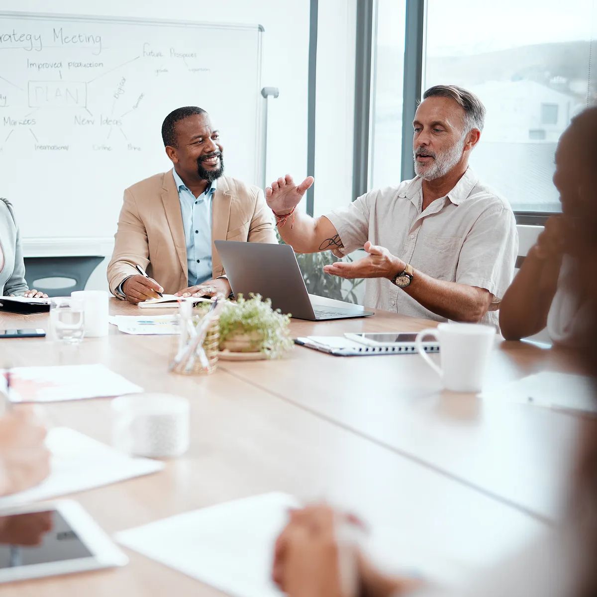 Shot of a group of staff listening to their boss during a business meeting.