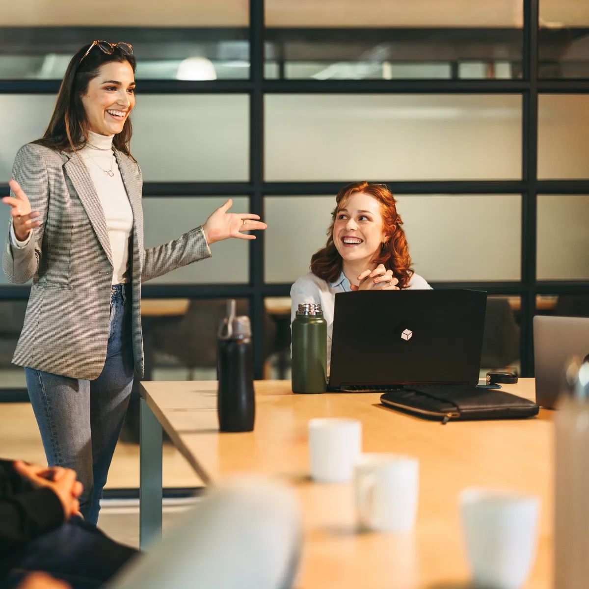 Diverse professionals, both men and women, brainstorming and discussing ideas in a lively office meeting. Led by a charismatic leader, this successful tech startup exemplifies the power of teamwork in project management.