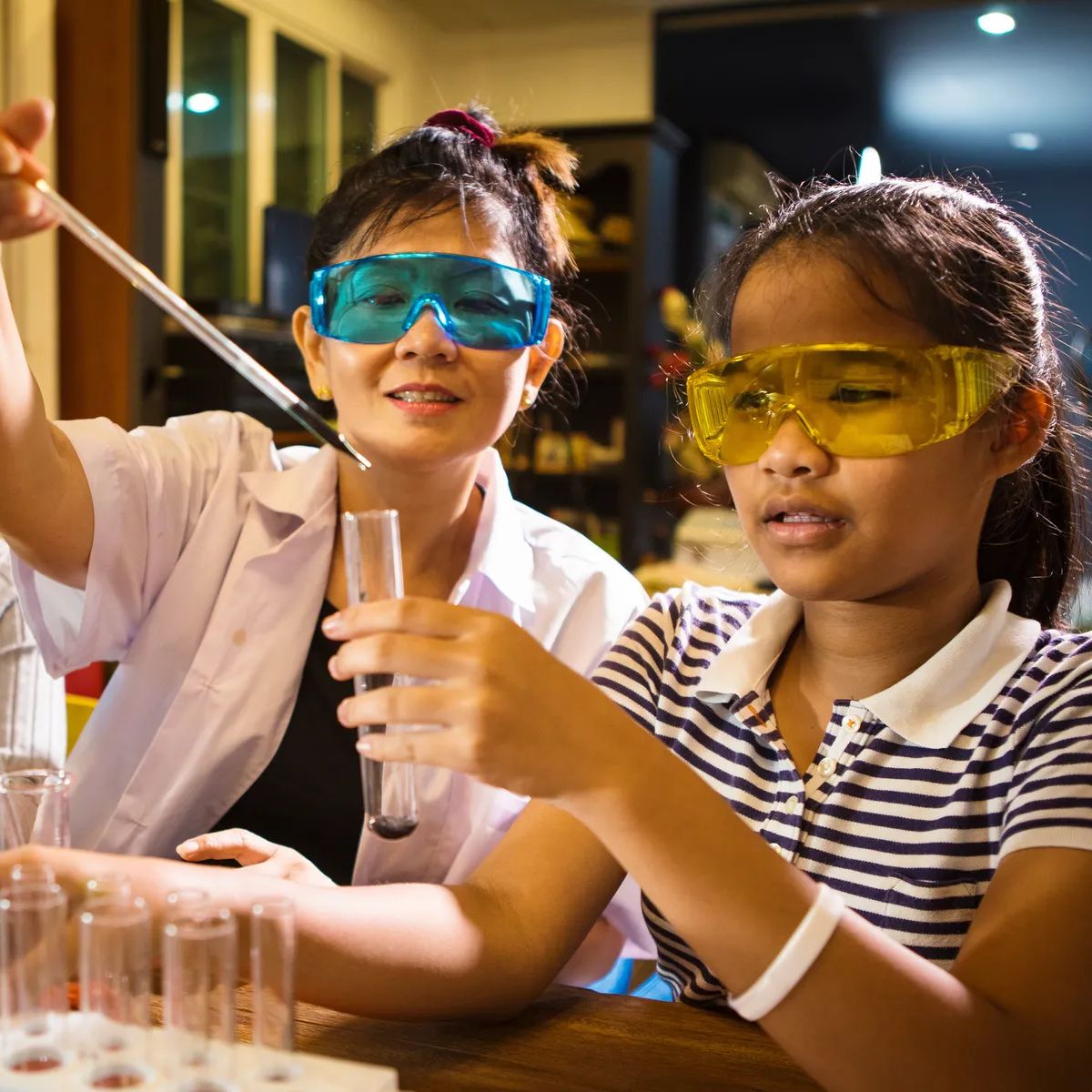 asian teacher and student in school science laboratory room