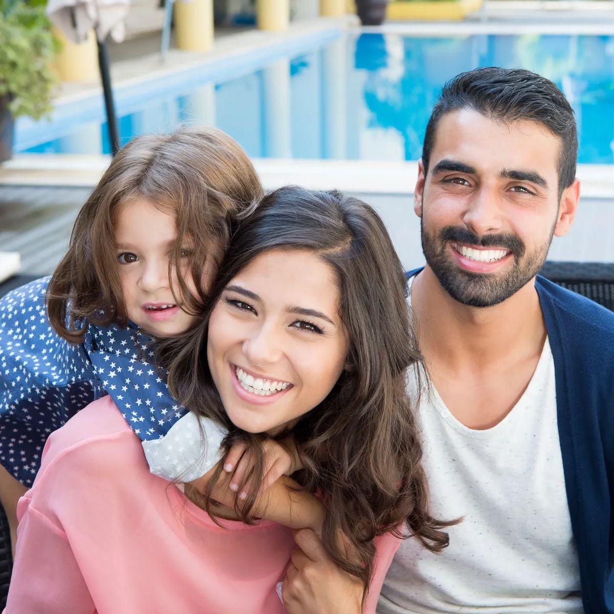 Beautiful latin family relaxing close to the pool