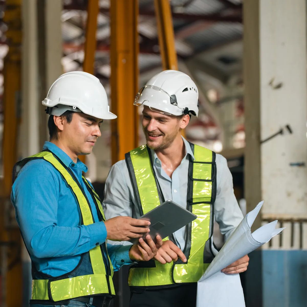 Engineers wearing safety helmets inspecting railway blueprint beside a vintage locomotive, symbolizing teamwork, innovation, and development in modern rail transportation and infrastructure projects