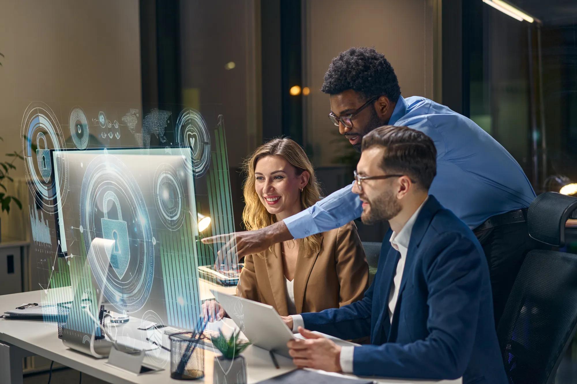 Professionals reviewing healthcare data on a computer, with a team member pointing to insights on screen to guide benefits strategy and cost analysis.
