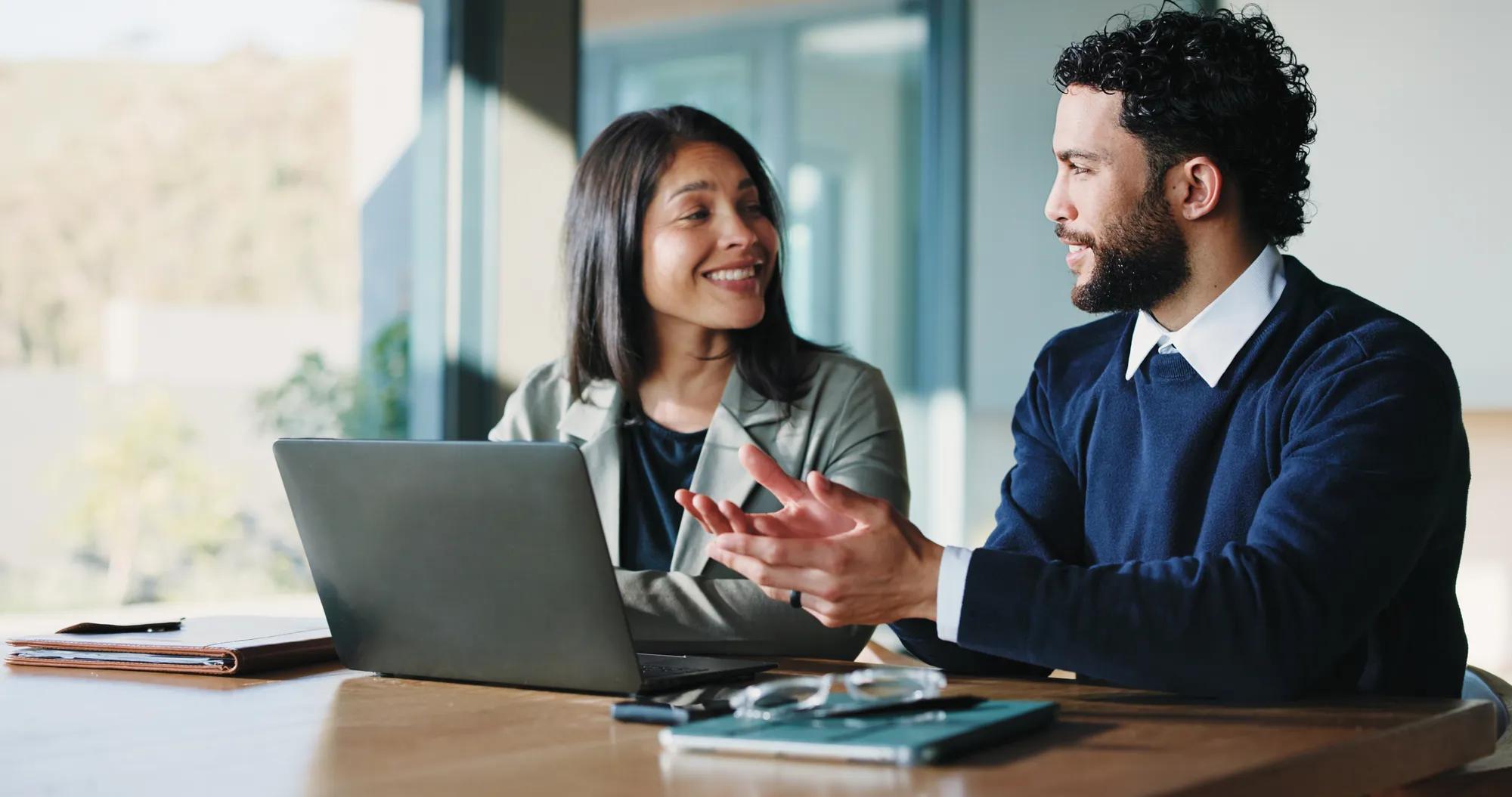 Meeting, laptop and talking with business people in office for realtor listing, discussion and research. Property developer, project manager and collaboration with employees for online review.