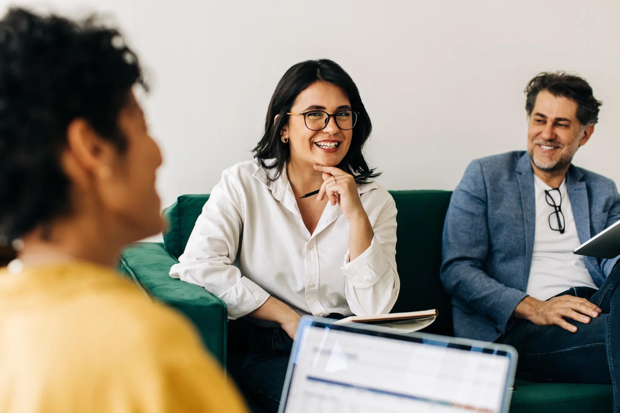 Business people having a meeting with their colleague in an office. Happy business professionals having an interview in a lobby. Promotion and internal recruitment in a workplace.