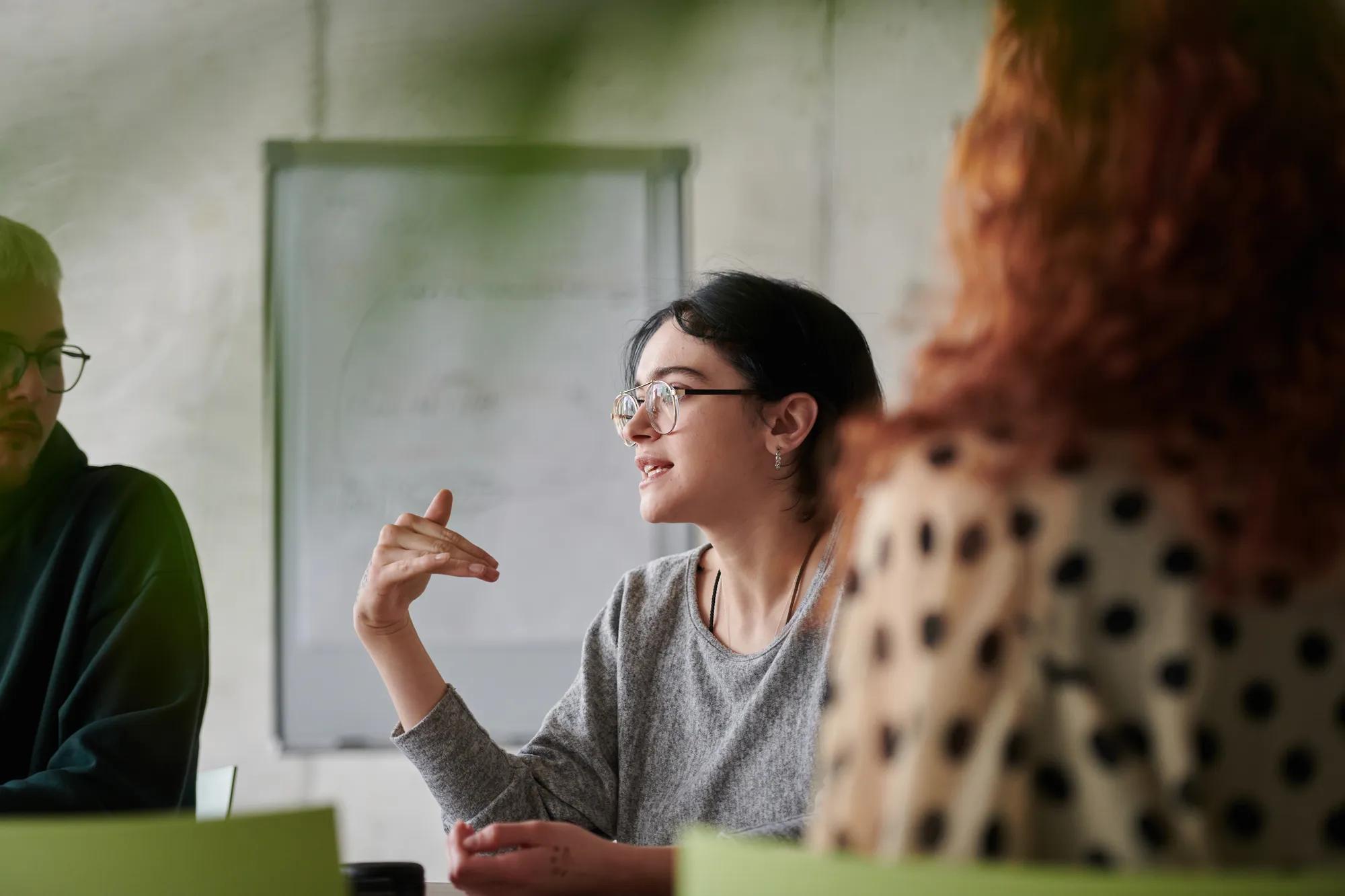 A diverse multiethnic business team engages in a collaborative meeting, discussing strategies and solutions in a modern office setting.