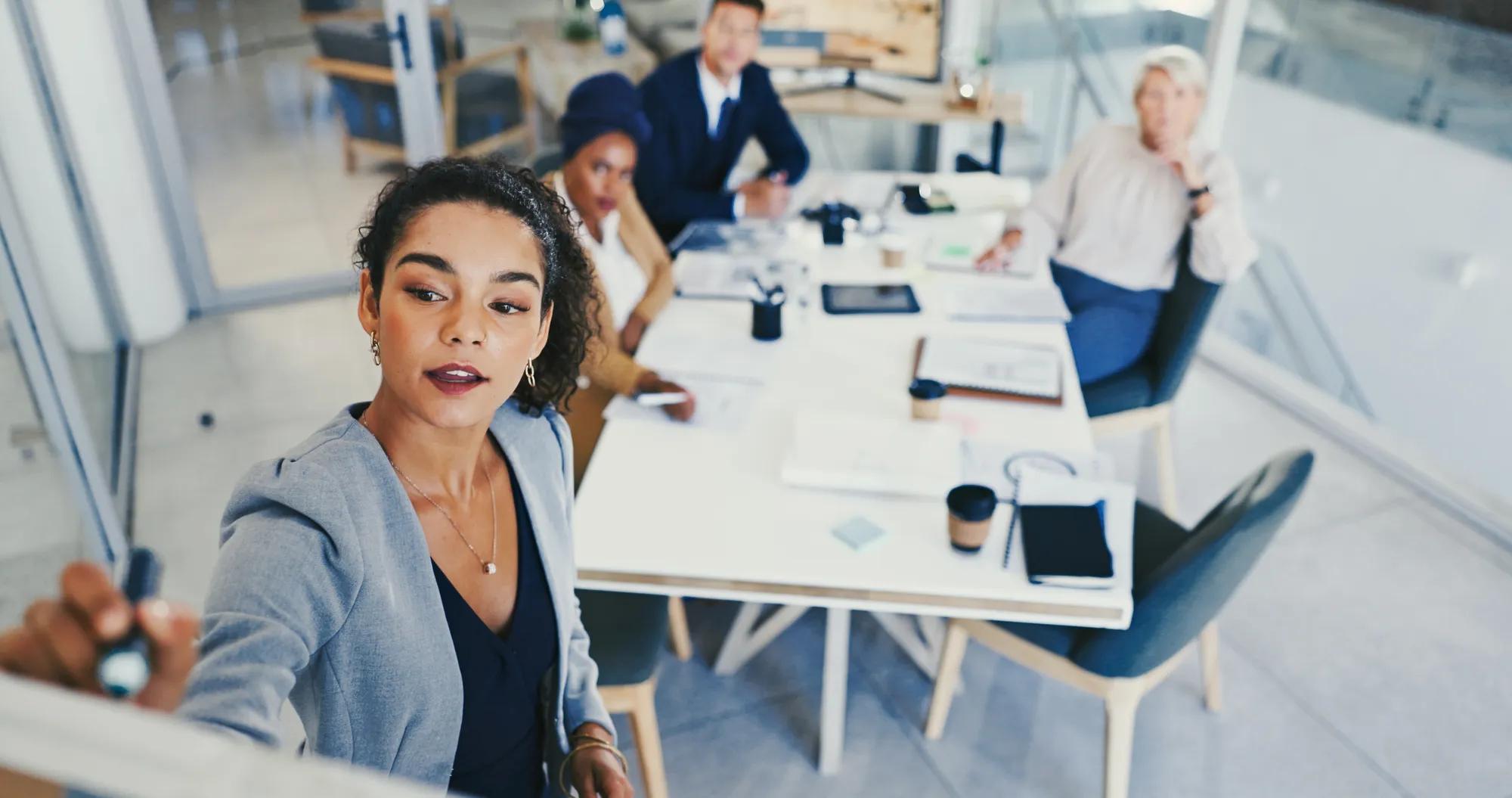 Business people, brainstorming and woman with whiteboard, above and planning for company growth. Employees, group and ideas in workshop, training and meeting for feedback, writing and review proposal.
