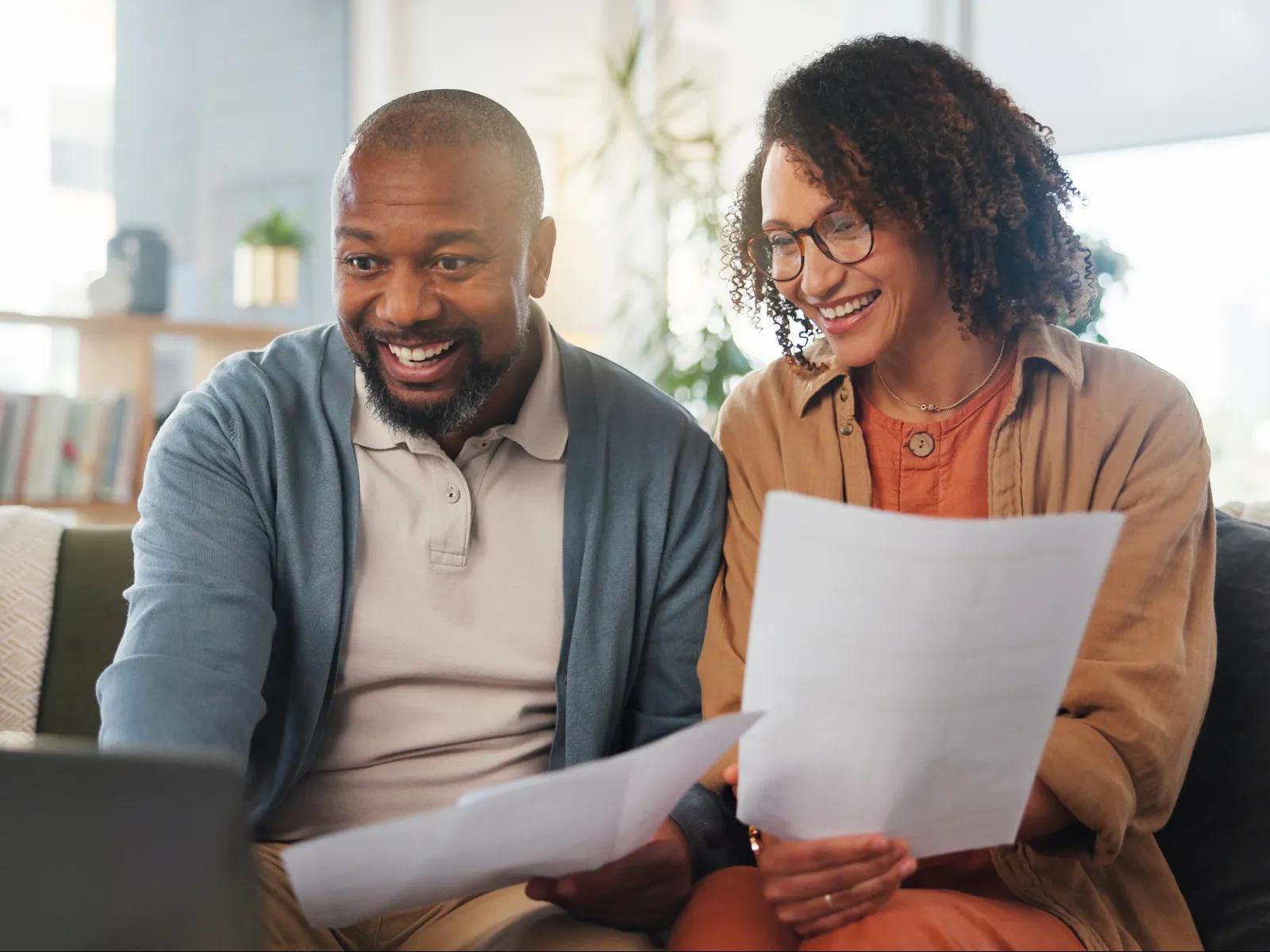 A couple reviewing health insurance and benefits documents at home.